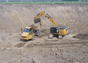 Excavator dumping dirt into a dump truck